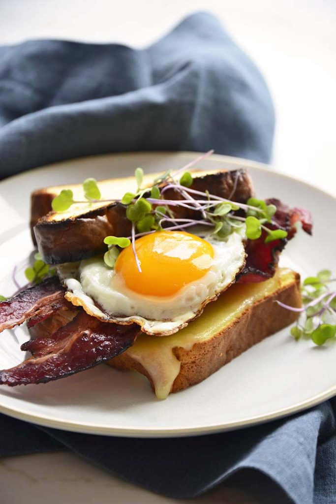 keto breakfast sandwich on a white plate with a blue napkin