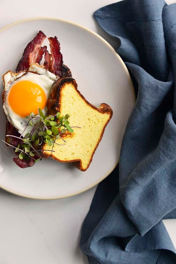 keto breakfast sandwich on a white plate with a blue napkin