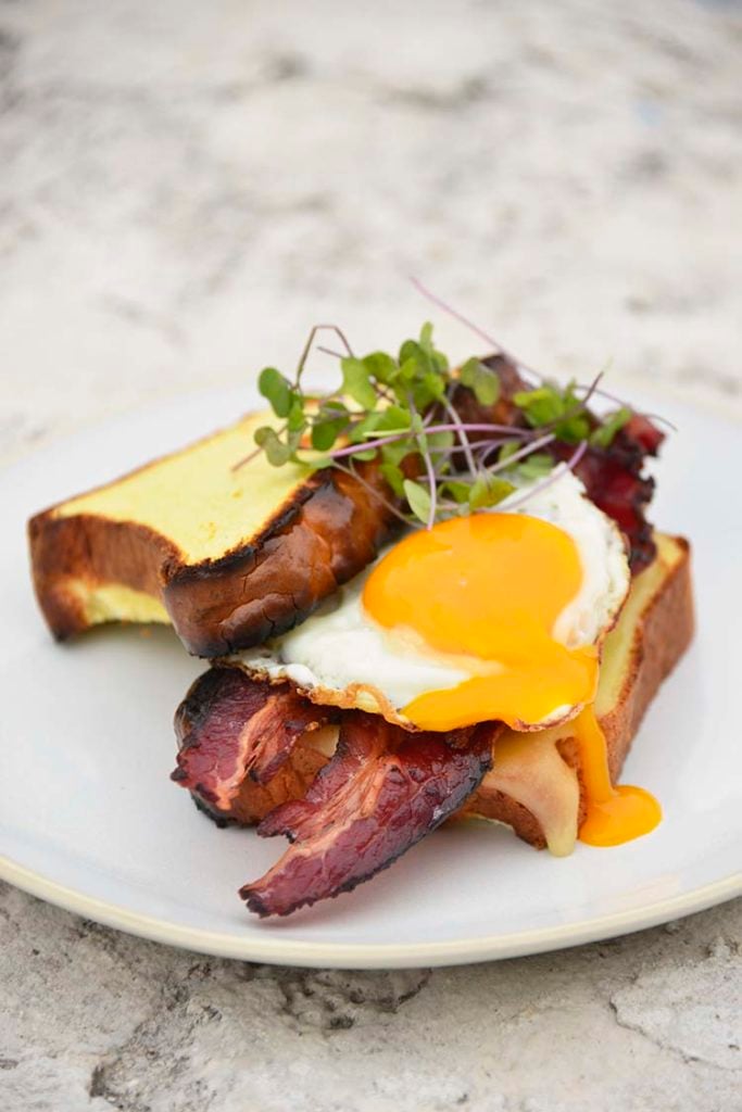 keto breakfast sandwich on a white plate topped with micro greens
