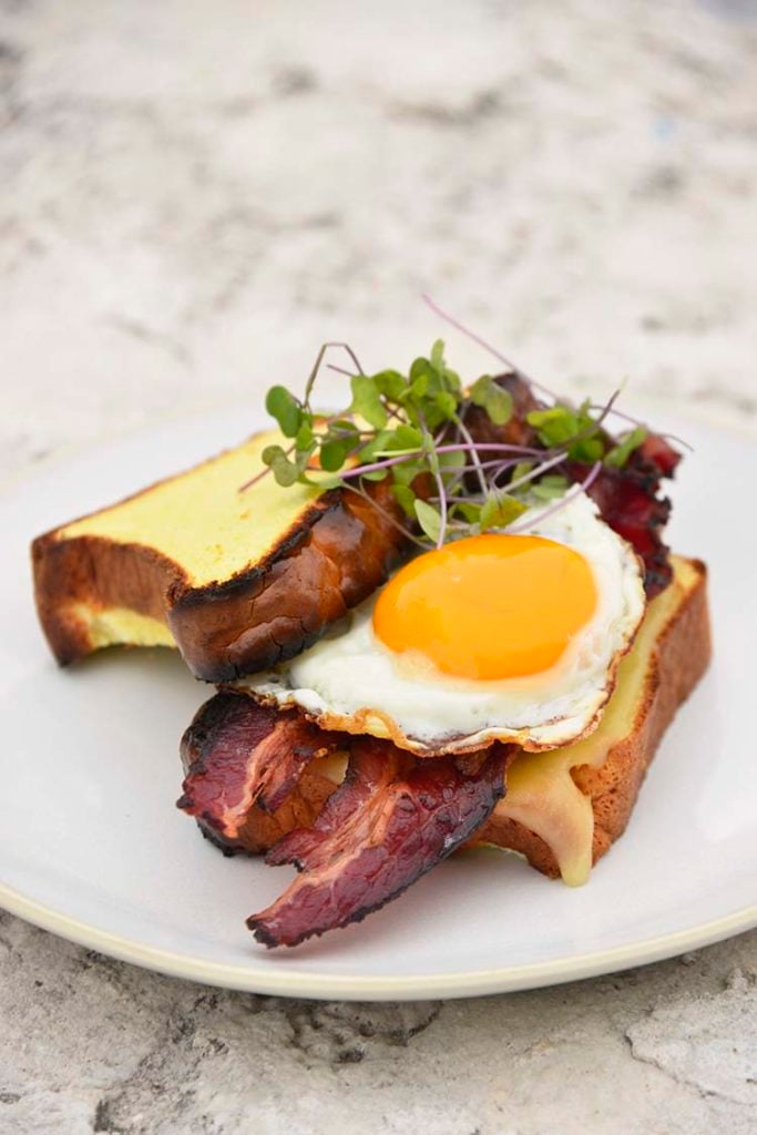 keto breakfast sandwich on a white plate topped with micro greens