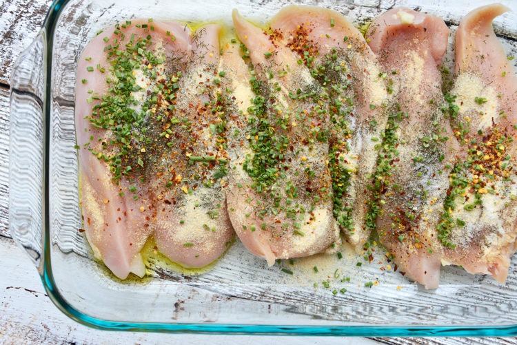 seasoned raw chicken in glass baking dish