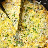 vertical image of a baked frittata in a cast iron skillet close up