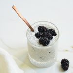 blackberry lemon chia pudding in a glass with a spoon and blackberries on top