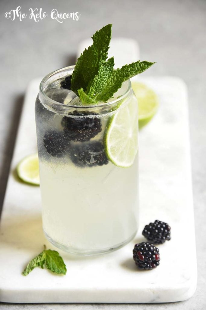 Blackberry Mojito Mocktail recipe in a clear glass garnished with mint, lime and blackberries