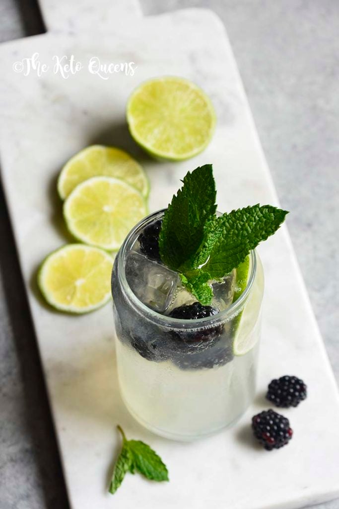 Blackberry Mojito Mocktail recipe in a clear glass garnished with mint, lime and blackberries