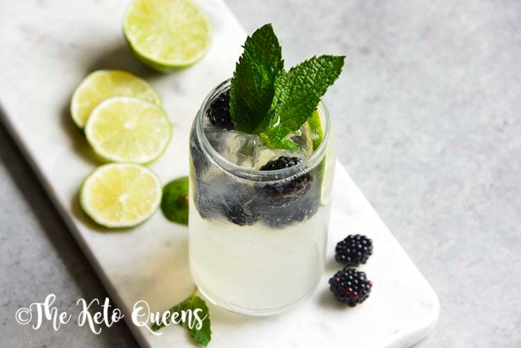 Blackberry Mojito Mocktail recipe in a clear glass garnished with mint, lime and blackberries