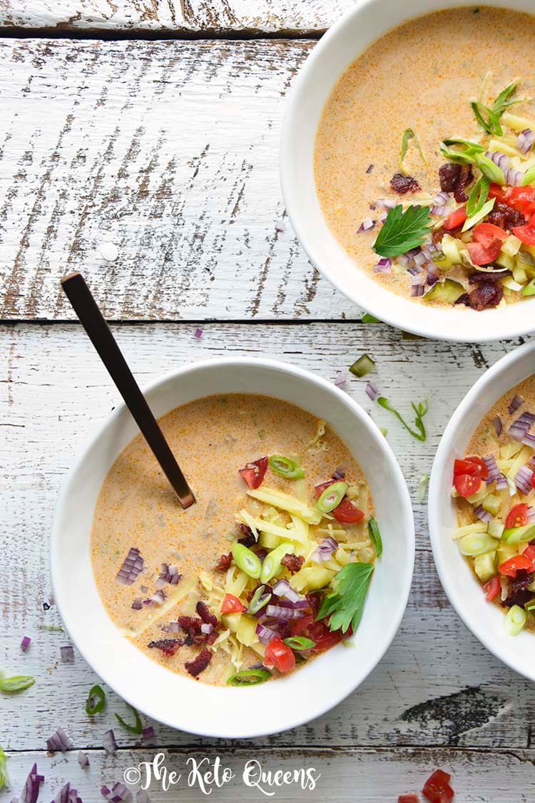 3 bowls of Keto Bacon Cheeseburger Soup with garnishes and a spoon