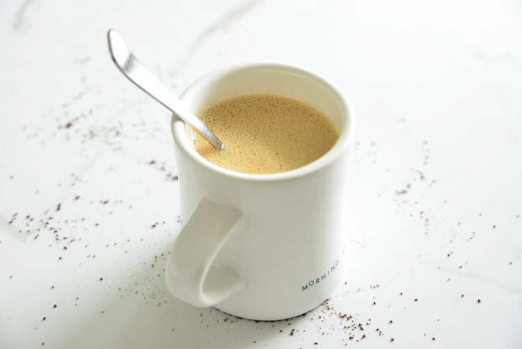 image of bulletproof coffee in a white mug with a spoon