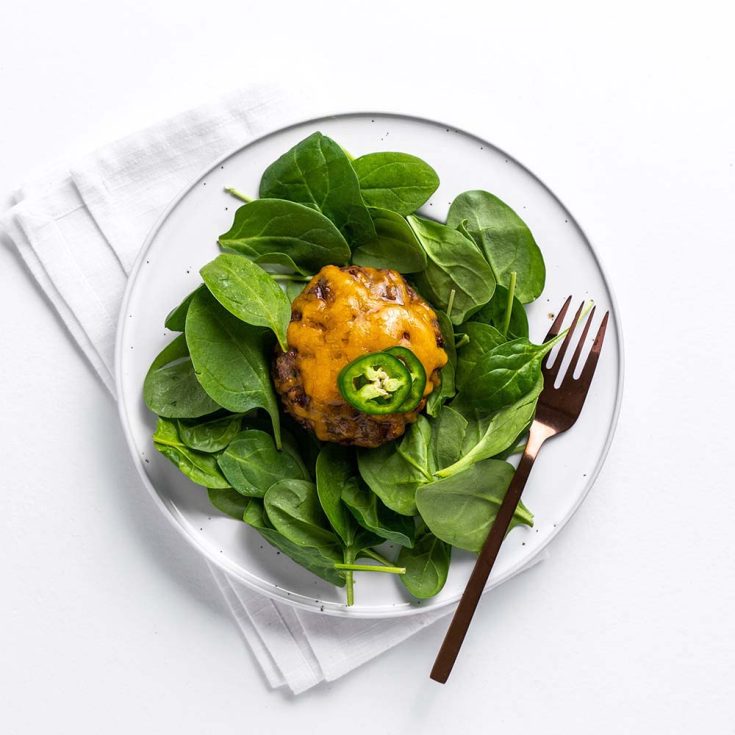 jalapeno cheddar burger on spinach