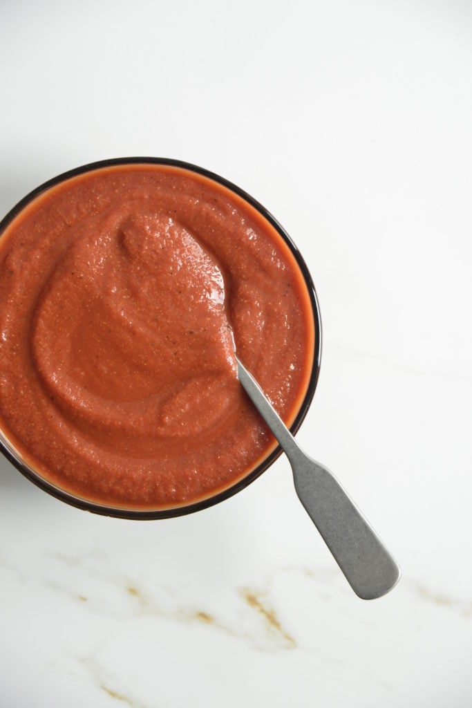 bowl of sugar free BBQ sauce i a clear bowl with a spoon