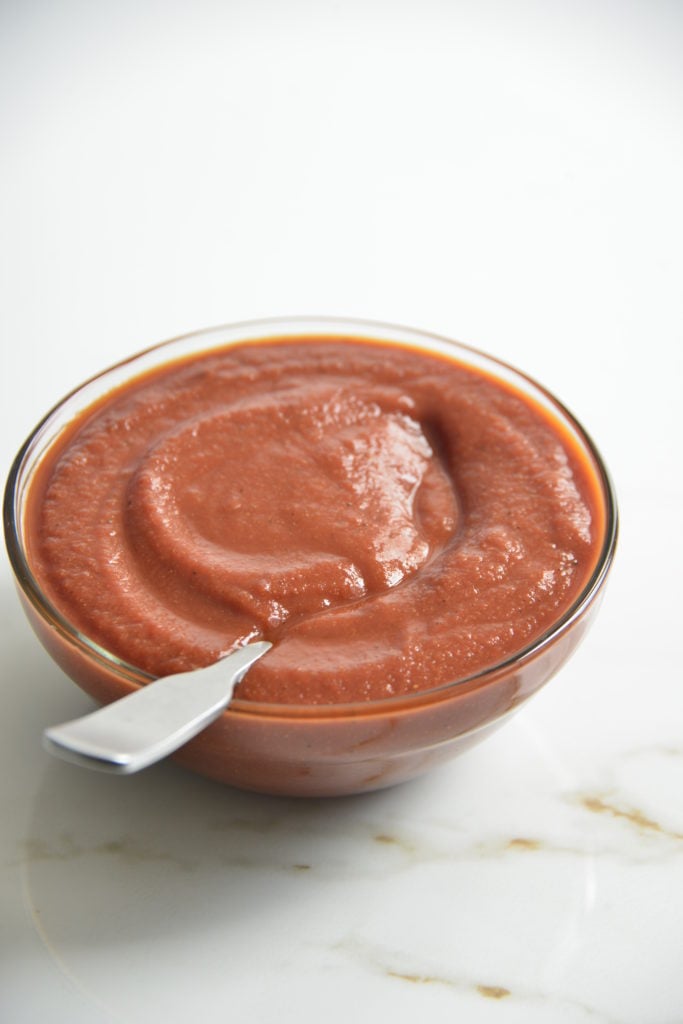 bowl of sugar free BBQ sauce i a clear bowl with a spoon