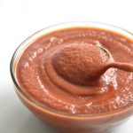 bowl of sugar free BBQ sauce i a clear bowl with a spoon
