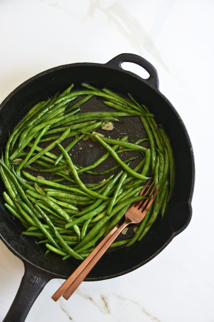 garlicky green beans cooked in a cast iron skillet