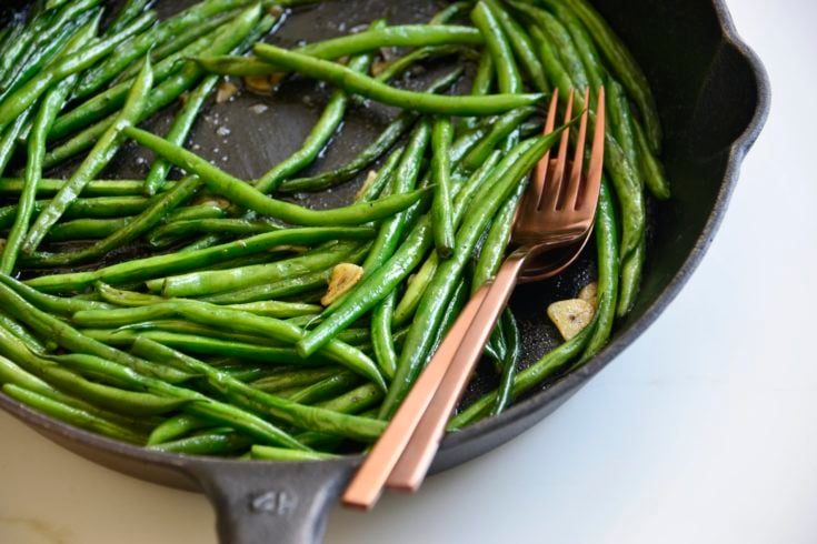 garlicky green beans cooked in a cast iron skillet
