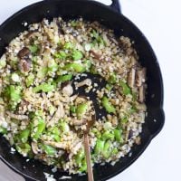 cauliflower fried rice in a cast iron skillet with a spoon