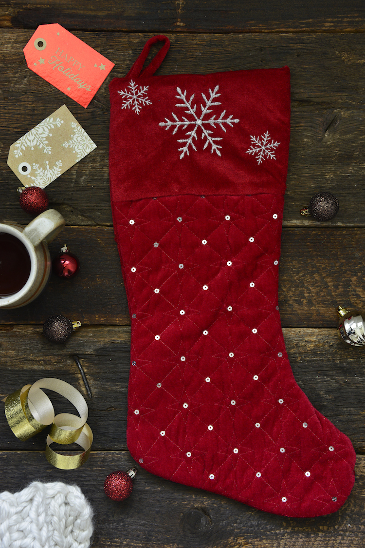 a black stocking on a dark board with tags and holiday themed