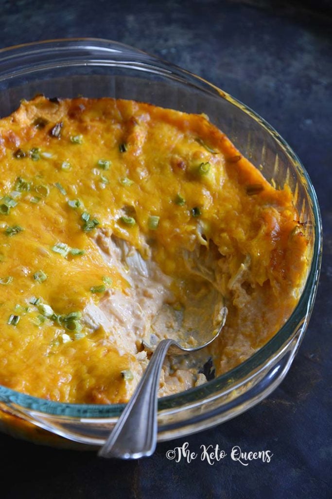 This Super Easy Buffalo Chicken Dip Recipe is the perfect appetizer for football Sundays, tailgating parties or to just have on hand as a keto snack. close up vertical image of buffalo chicken dip with a spoon in a glass bowl