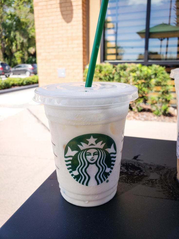 Tired of boring black coffee? Check out my top 5 Keto Starbucks Drinks to brighten your morning. picture of a keto white drink on a table outside of starbucks