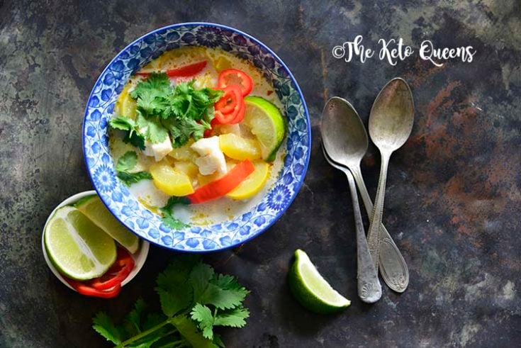 Horizontal image of a bowl of thai coconut curry with red bell peppers and yellow squash.