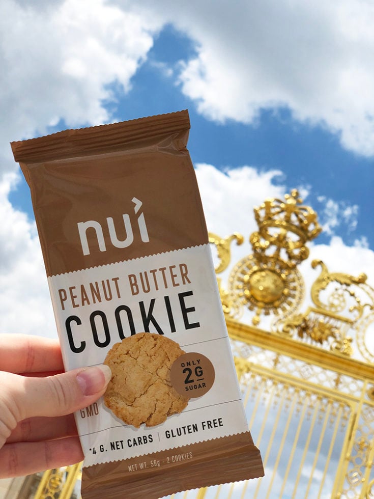 Nui Keto Cookie, a keto travel snack in front of the Golden gates of Versailles