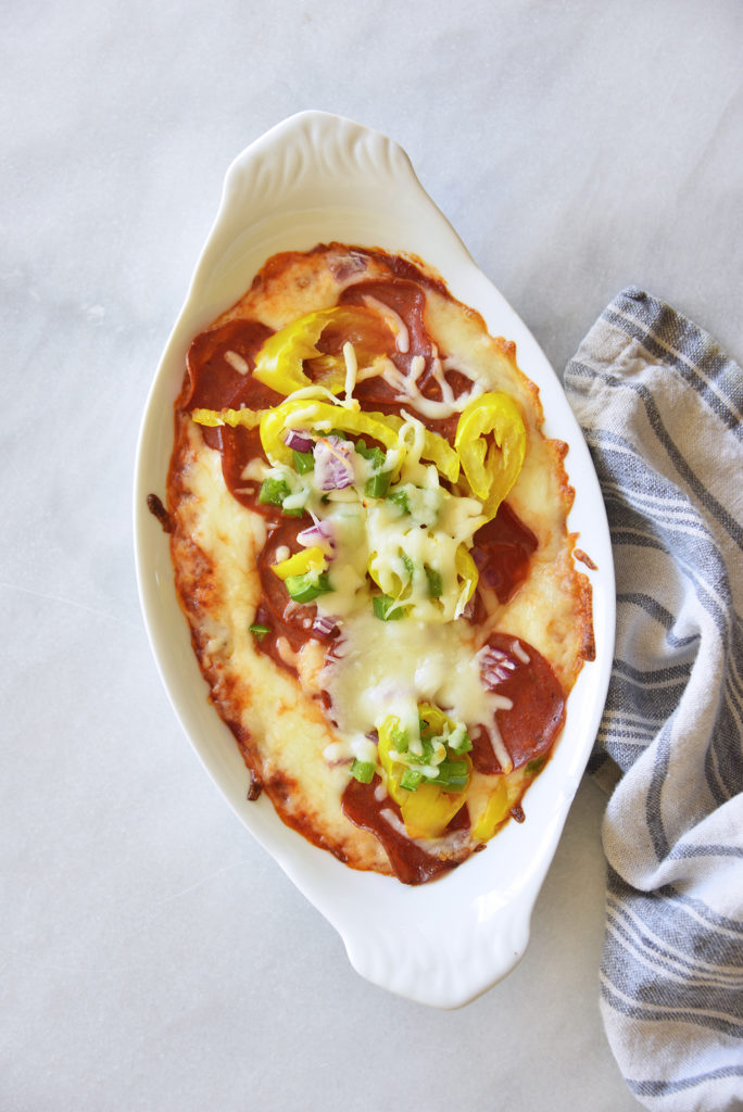 Easy Keto Pepperoni Pizza Dip Recipe in a white casserole dish with kitchen towel