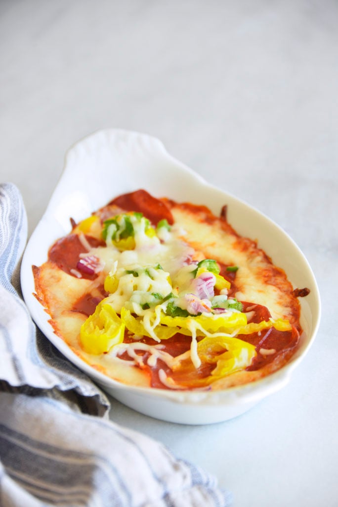 Easy Keto Pepperoni Pizza Dip Recipe in a white casserole dish with kitchen towel