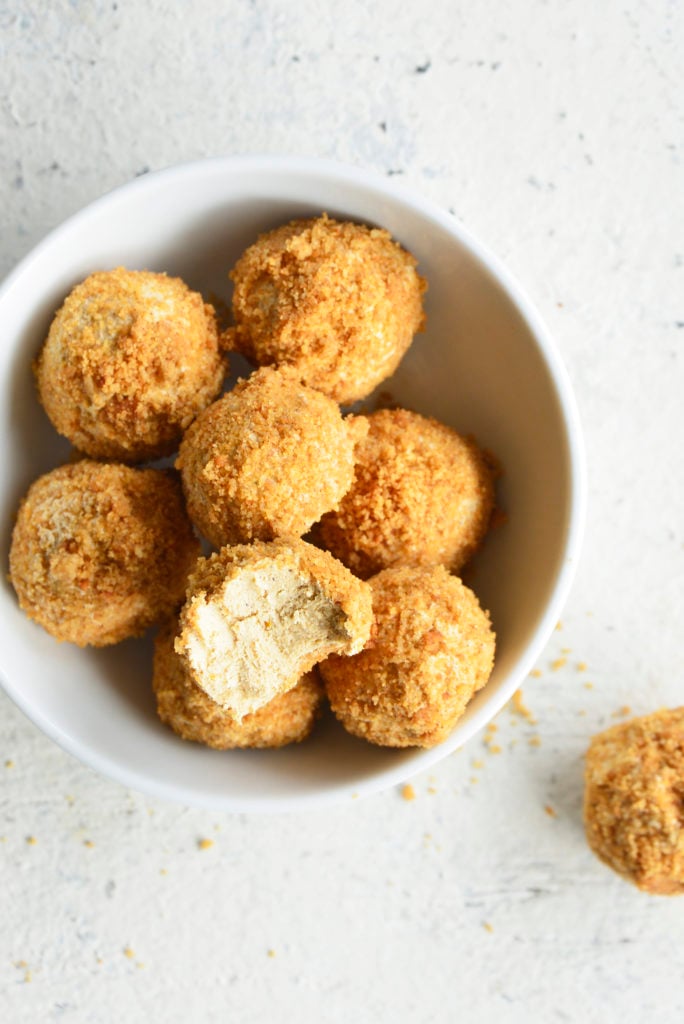 Keto Pumpkin Spice Cream Cheese Fat Bombs in a white bowl with a bite taken out