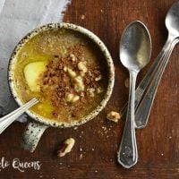 pumpkin spice keto oatmeal noatmeal recipe in a mug with spoons and a linen on a wood backdrop