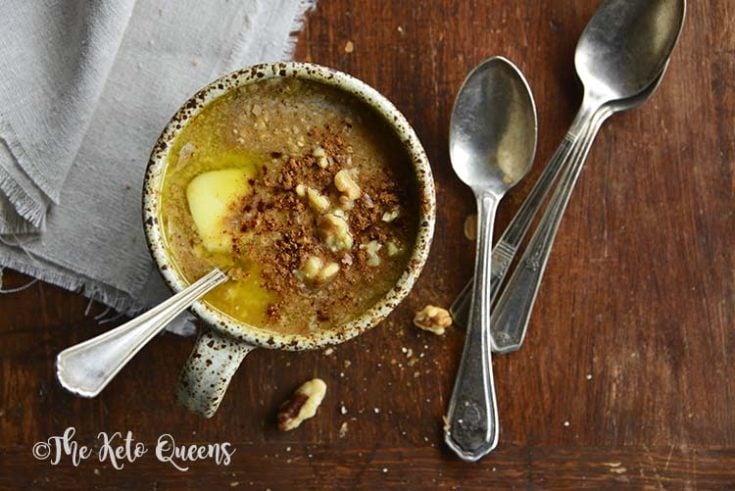 pumpkin spice keto oatmeal in a mug with spoons and linen on a wood surface