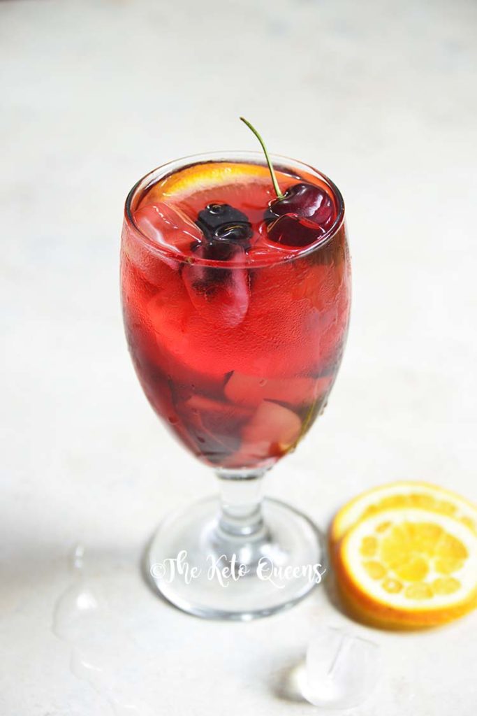 keto sangria mocktail recipe in a clear glass garnished with cherries and orange slices