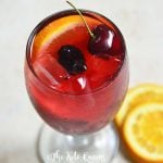 keto sangria mocktail recipe in a clear glass garnished with cherries and orange slices