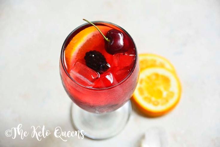keto sangria mocktail recipe in a clear glass garnished with cherries and orange slices