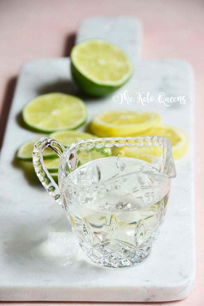 keto simple syrup in a glass with lemons and limes