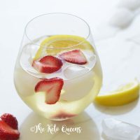 iced strawberry lemon tea in a seamless wine glass with lemon wedges