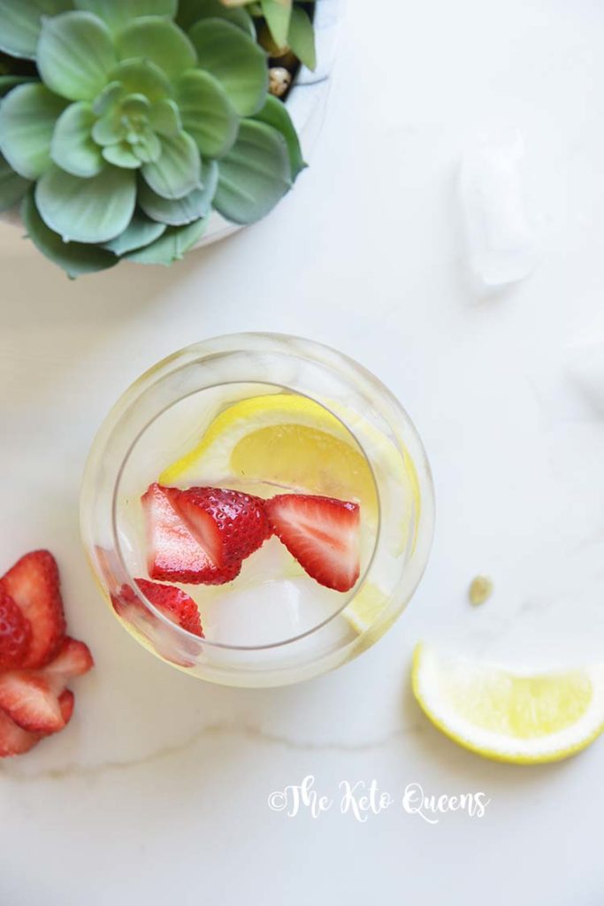 iced strawberry lemon tea in a seamless wine glass with lemon wedges with a succulent