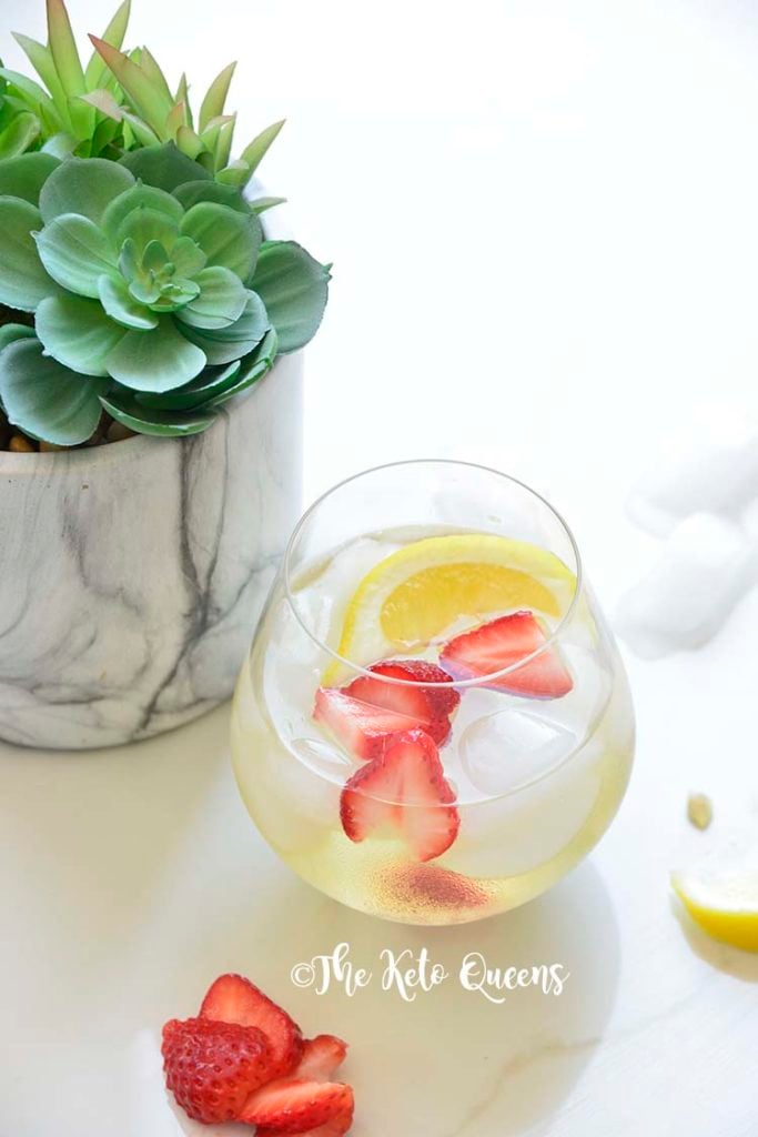 iced strawberry lemon tea in a seamless wine glass with lemon wedges and a succulent