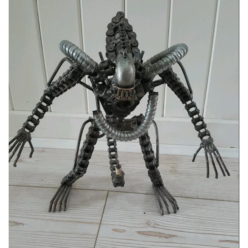 Predator sculpture made from motor parts.